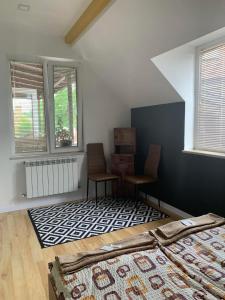 a bedroom with a bed and two chairs and a rug at Trakia Street Apartment in Plovdiv