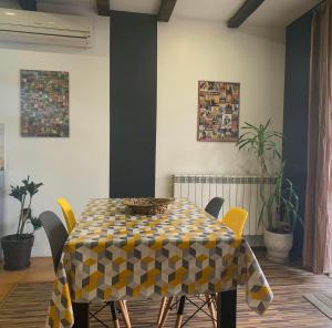 a dining room table with yellow chairs around it at Trakia Street Apartment in Plovdiv