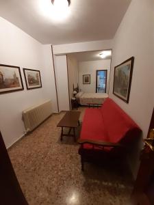 a living room with a red bed and a couch at Hotel Andalucía in Cazorla