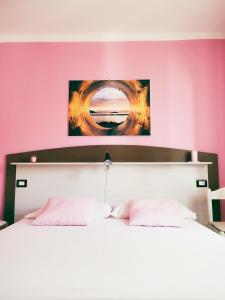 a bedroom with a large bed with pink walls at Le Sirene Castellabate in Santa Maria di Castellabate