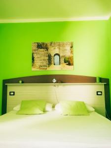 a bedroom with a green wall with a bed at Le Sirene Castellabate in Santa Maria di Castellabate
