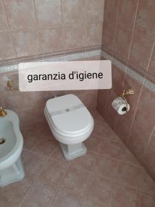 La salle de bains est pourvue de toilettes blanches et d'un lavabo. dans l'établissement Sweet House Only Rooms, à Peschiera del Garda