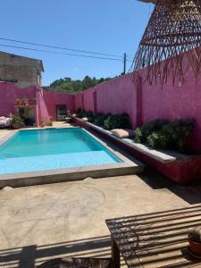 a swimming pool in front of a pink wall at São Miguel House , Casa do Carvalhal in Santarém