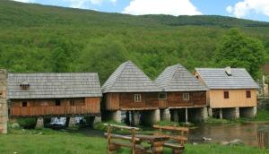 a group of wooden houses in a field at Apartman Eva Maria in Otočac