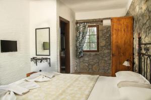 a bedroom with a large bed and a window at Doga Apartments in Kayakoy
