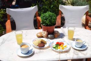 stół z talerzami jedzenia i kubkami kawy w obiekcie Aegina House w mieście Egina