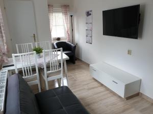 ein Wohnzimmer mit einem Sofa und einem Tisch mit einem TV in der Unterkunft Holiday Home Domeček in Lipová-lázně