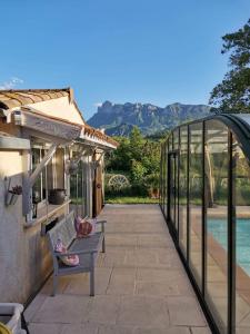 a patio with a bench next to a house at Chambre double "le pêcher" saillans in Saillans