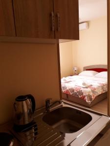 a kitchen with a sink and a bed at Apartmani Sara Trebinje in Trebinje