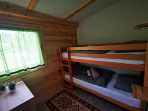 ein Schlafzimmer mit Etagenbetten in einem Blockhaus in der Unterkunft Wooden House "Una" in Kulen Vakuf