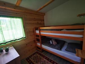 a bedroom with bunk beds in a log cabin at Wooden House "Una" in Kulen Vakuf