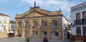 un vieux bâtiment avec une horloge en haut dans l'établissement Casita de Rosario, à Cortes de la Frontera