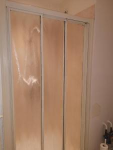 une porte en verre d'une armoire dans une pièce dans l'établissement Le Majestic 103, à Aix-les-Bains