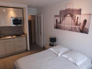 sypialnia z łóżkiem i zdjęciem molo w obiekcie Le Majestic 103 w Aix-les-Bains