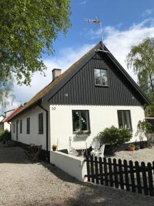 biały domek z czarnym dachem w obiekcie Rum på landet w mieście Klagstorp