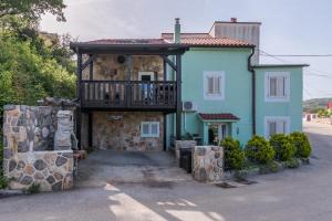 a blue house with a balcony on top of it at Stone House Knez in Vrbnik