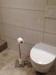 een badkamer met een toilet en een rol toiletpapier bij Emmerich s neu errichtete DG-Wohnung in Bad Wildungen