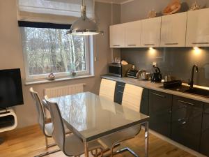 a kitchen with a table and chairs and a window at Apartament Środziemnomorski in Jastrzębia Góra