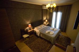 a bedroom with a bed with two towels on it at Delfini Hotel in Menídion