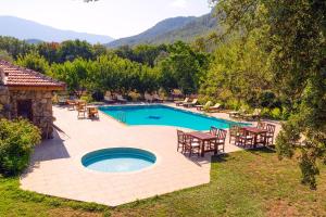 a swimming pool with tables and chairs in a yard at Doga Apartments in Kayakoy