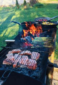 a grill with a bunch of meats and pans on it at Sepa Talu in Aakre