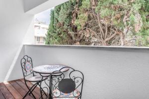 einen Tisch und zwei Stühle auf einem Balkon mit Fenster in der Unterkunft Stunning 1 BDR with balcony on Sheinkin st in Tel Aviv
