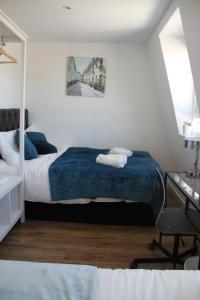 um quarto com uma cama e uma secretária com uma cadeira em Kamilla's Rooms London Zone-1 em Londres