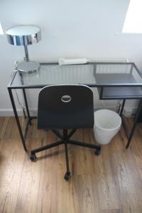 a glass desk with a chair in a room at Kamilla's Rooms London Zone-1 in London