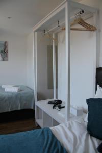 1 dormitorio con espejo junto a la cama en Kamilla's Rooms London Zone-1 en Londres