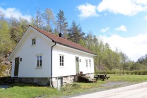 a white building with a picnic table in a field at Det Hvite Hus in Feda