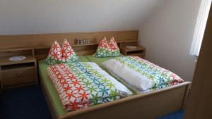 a bedroom with two twin beds with colorful pillows at Hausnordlicht FEWO 4 in Dornum