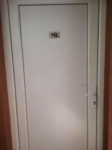 Una puerta blanca con un cartel. en Guest Accommodation Azucki, en Novi Bečej
