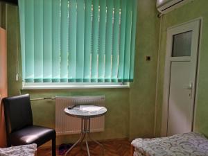 a room with a table and a chair and a window at Guest Accommodation Azucki in Novi Bečej