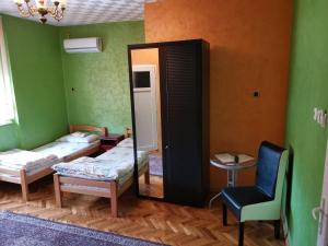 a room with two beds and a mirror and a chair at Guest Accommodation Azucki in Novi Bečej