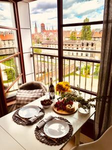 einen Tisch mit zwei Teller Essen und einem Fenster in der Unterkunft Nova Motlava Old Town Apartment in Danzig