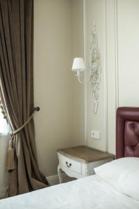 a bedroom with a bed and a table next to a window at Old Town River Apartments in Klaipėda