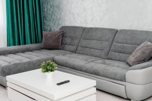 a living room with a gray couch and a white coffee table at Apartament Central Radu in Sibiu