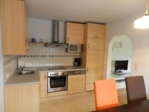 a kitchen with wooden cabinets and a stove top oven at Apartment Kirchenblick in Weissenkirchen in der Wachau