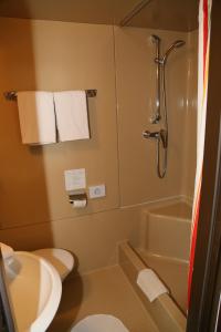 a bathroom with a toilet and a shower with towels at Strandhotel Pichler in Seeboden