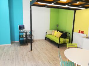 a living room with a green couch and a table at 2 LOFTS guest house in Turin