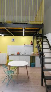 une cuisine en mezzanine avec une table et un escalier dans l'établissement 2 LOFTS guest house, à Turin