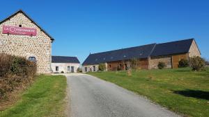 une grange avec un panneau sur le bord d'une route dans l'établissement La Corbonniere, à Geneslay