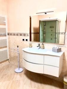 La salle de bains est pourvue d'un lavabo blanc et d'un miroir. dans l'établissement B&B la Serenissima, à Fossalta di Portogruaro