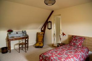 a bedroom with a bed and a desk and a sink at Chambre d'Hôtes chez Artiste Verrier, La Perrière - Perche in La Perrière