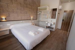 a bedroom with a large white bed and a sink at Casa Nahia Hostal Rural in Lorca