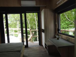 阿伊多夫什契納的住宿－Small holiday houses，一间卧室设有一张床和一个滑动玻璃门
