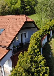 a house with a red roof and some trees at Domek i Apartamenty Zacisze in Brenna