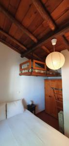 Un dormitorio con una cama blanca y una lámpara. en Casa Alentejana, en Estrela