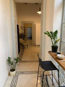 un pasillo con mesa, sillas y plantas en Luxury Valletta Apartment, en La Valeta