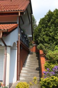 a stairway leading up to a house with flowers at Domek i Apartamenty Zacisze in Brenna